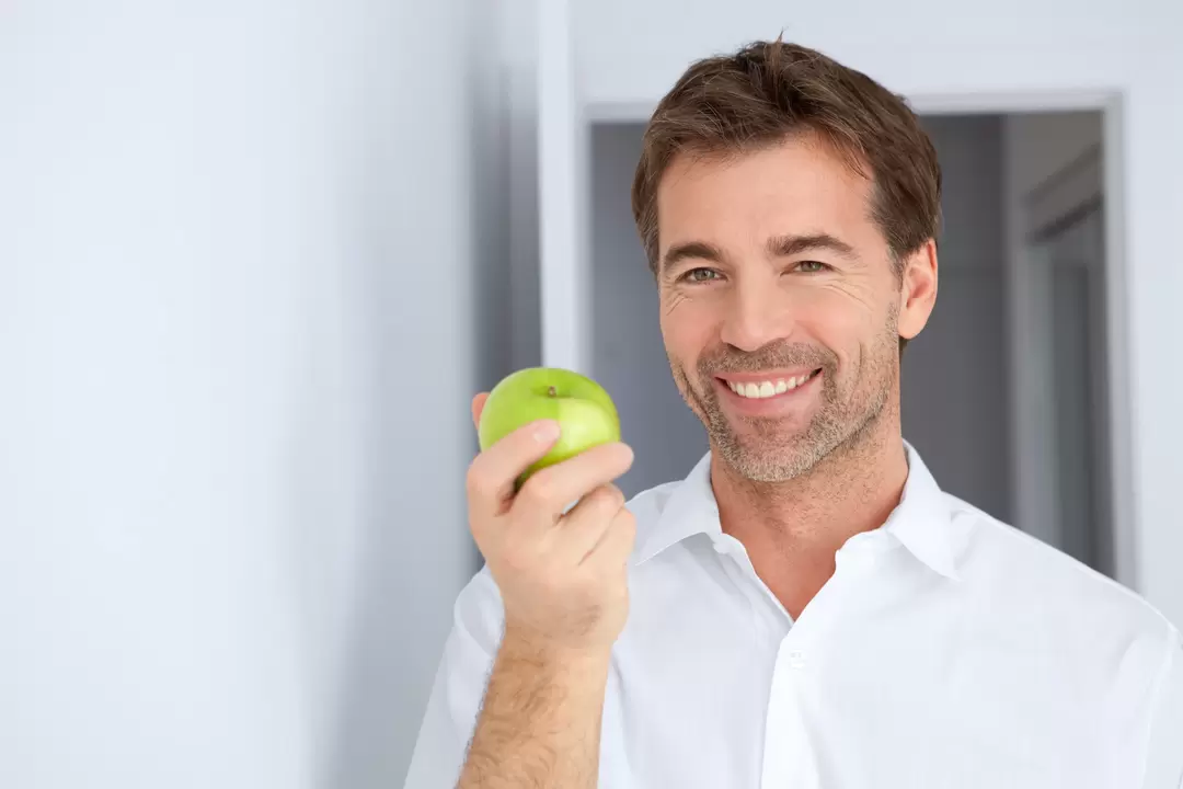 A man eats an apple for strength